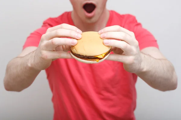 Homme mangeant un hamburger — Photo
