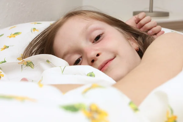Kind meisje op het bed — Stockfoto