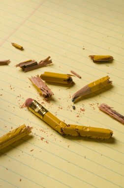 Sarı kağıt üzerinde kırık kalem parçaları