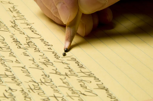 Handschrift met gebroken potlood wijs op gele pad — Stockfoto