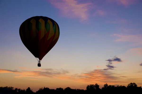 Balonu na ogrzane powietrze unoszące się przed świtem czerwone niebo — Zdjęcie stockowe