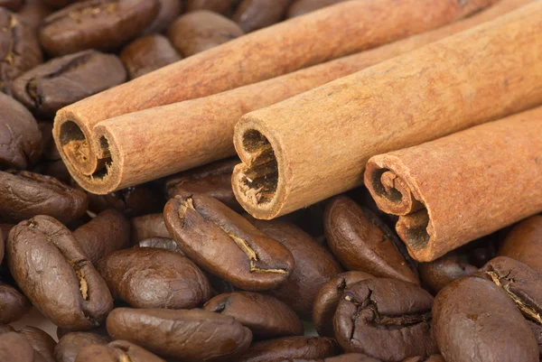 Primer plano: palitos de canela sobre los granos de café — Foto de Stock