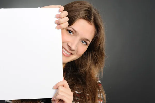 Молодая женщина держит пустую белую доску — стоковое фото