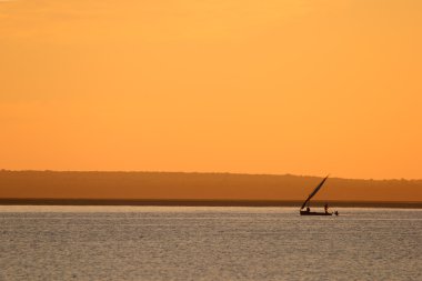 Mozambican dhow at sunset clipart