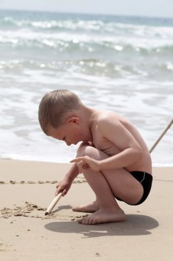 Boy playing on the beach clipart