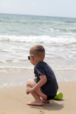 Boy playing on the beach clipart