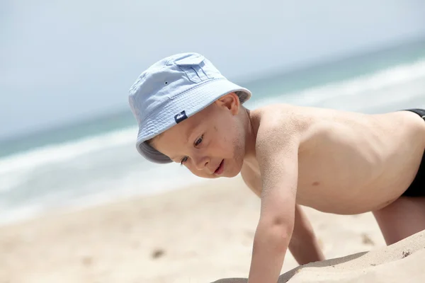 Menino de chapéu azul na praia — Fotografia de Stock
