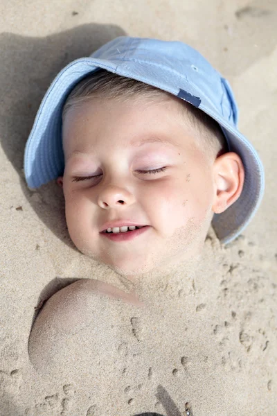 Chłopiec pochowany w piasek — Zdjęcie stockowe