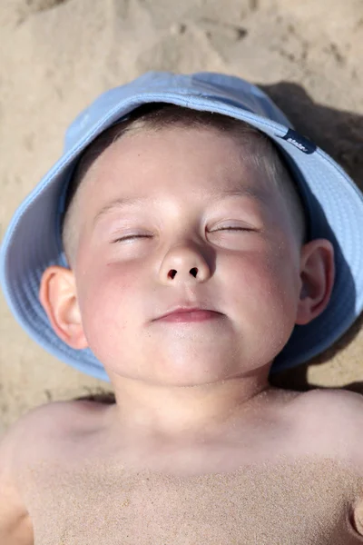 小男孩躺在海滩上 — 图库照片
