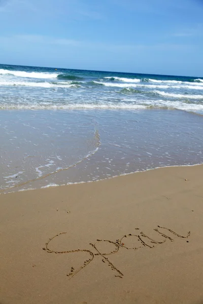 Costa marítima espanhola com escrita em areia — Fotografia de Stock
