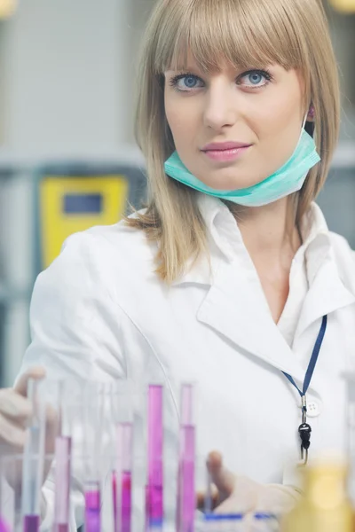 Kvinnlig forskare håller upp ett provrör i labbet — Stockfoto