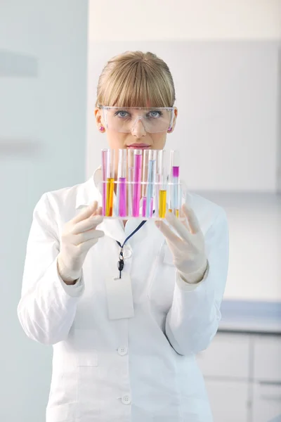 Female researcher holding up a test tube in lab — Stock Photo, Image