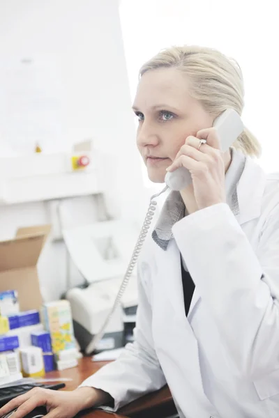Pharmacy worker talking by phone — Stock Photo, Image