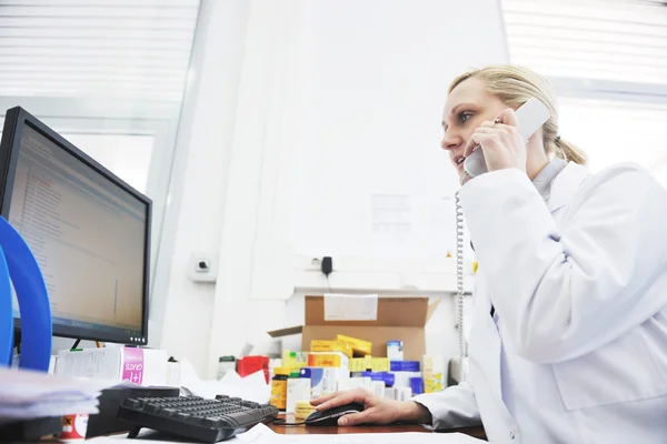 Pharmacy worker talking by phone — Stock Photo, Image