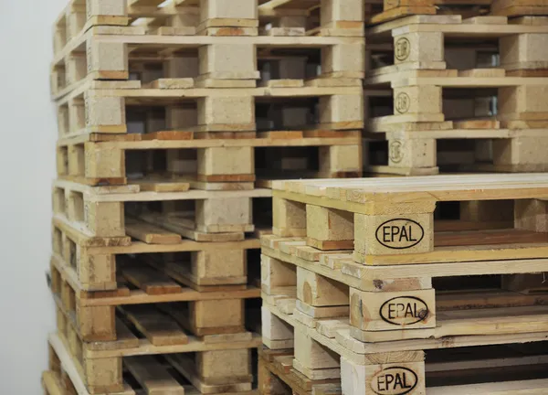Paletas de madera en almacén — Foto de Stock