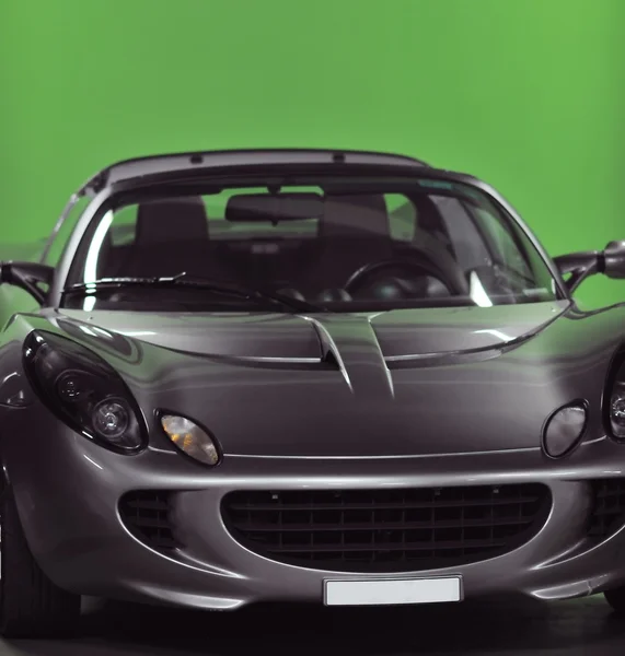 Спортивный автомобиль с зеленым фоном — стоковое фото