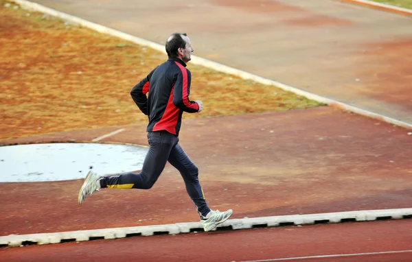 Homme adulte courir sur la piste d'athlétisme — Photo