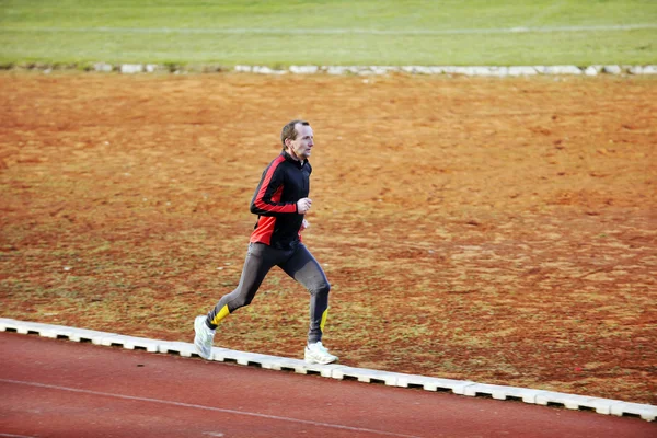 Felnőtt férfi futó atlétikai pálya — Stock Fotó