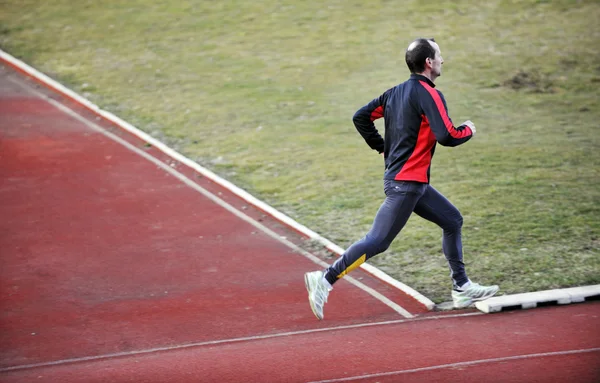 Hombre adulto corriendo en pista de atletismo — Foto de Stock