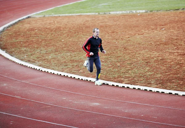 Felnőtt férfi futó atlétikai pálya — Stock Fotó