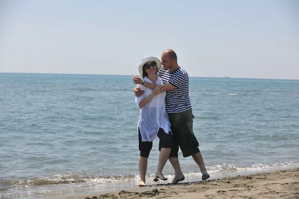 Szczęśliwa młoda para baw się na plaży — Zdjęcie stockowe