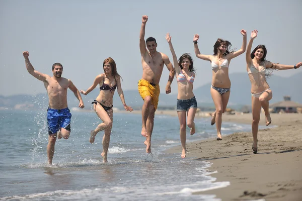 幸せなグループがビーチで楽しさと実行 — ストック写真