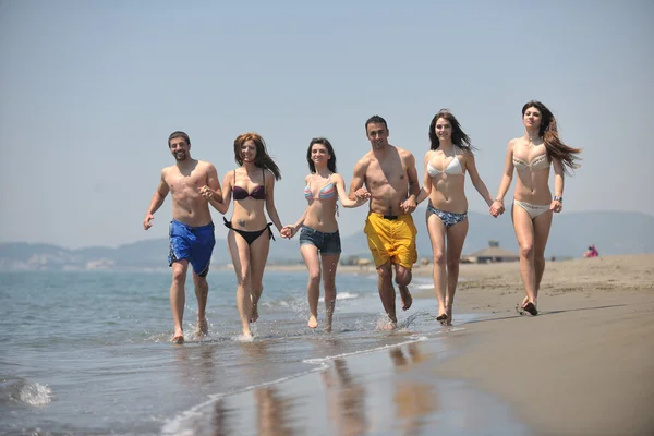 Heureux groupe avoir amusant et courir sur la plage — Photo