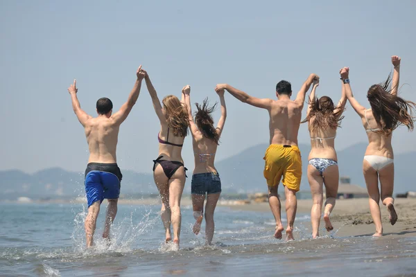 快乐组有乐趣和正在运行的海滩上 — 图库照片