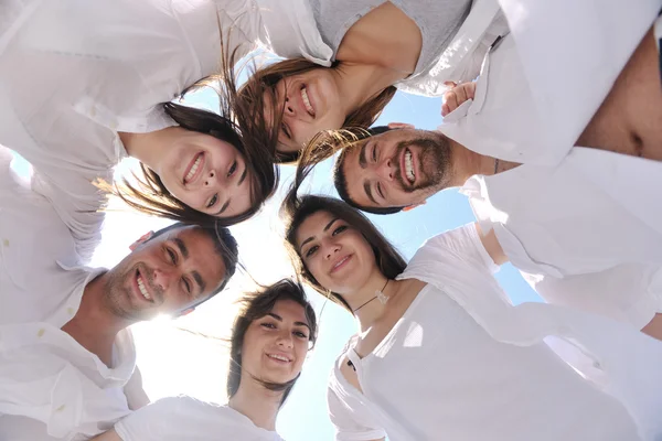 Skupina happy mladých v kruhu na pláži — Stock fotografie
