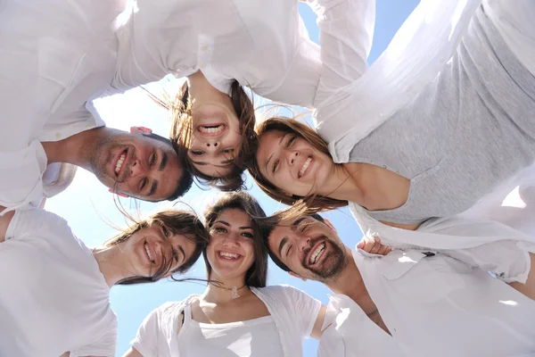 Skupina happy mladých v kruhu na pláži — Stock fotografie
