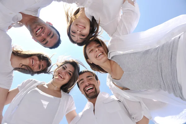 Grupp glada unga i cirkel på stranden — Stockfoto