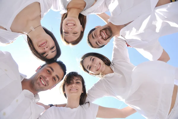 Group of happy young in circle at beach — Stock Photo, Image
