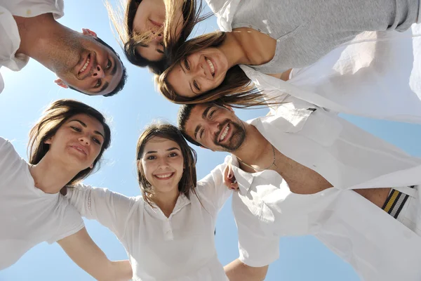 Group of happy young in circle at beach — Stock Photo, Image