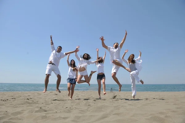 Glad grupp har roligt och kör på stranden — Stockfoto