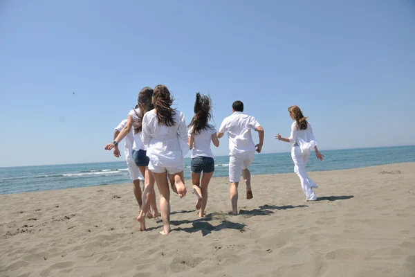 Щаслива група розважається і бігає на пляжі — стокове фото