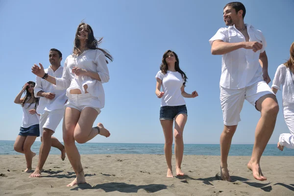 Grupo feliz divertirse y correr en la playa —  Fotos de Stock