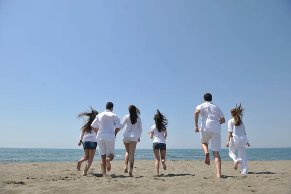 Fröhliche Gruppe hat Spaß und läuft am Strand — Stockfoto