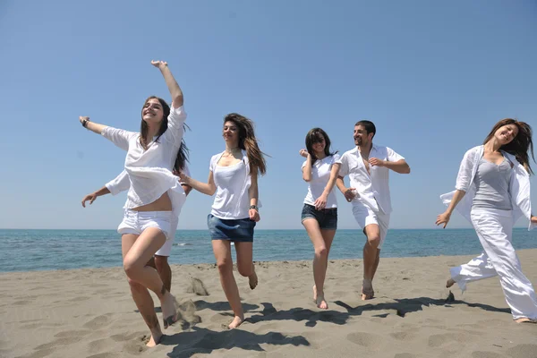 Grupo feliz se divertir e correr na praia — Fotografia de Stock