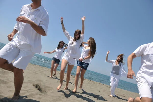 Grupo feliz se divertir e correr na praia — Fotografia de Stock