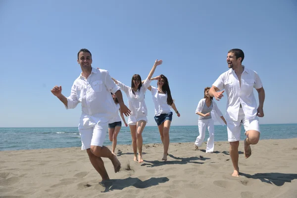 Счастливая группа веселится и бегает по пляжу — стоковое фото