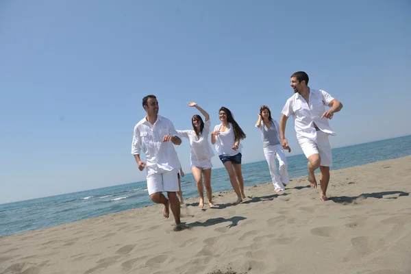 Fröhliche Gruppe hat Spaß und läuft am Strand — Stockfoto