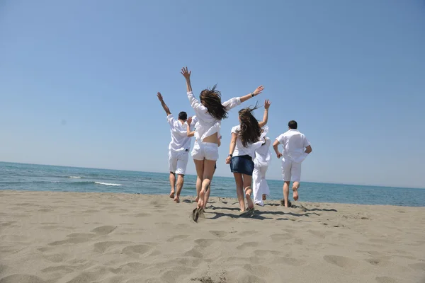 幸せなグループがビーチで楽しさと実行 — ストック写真