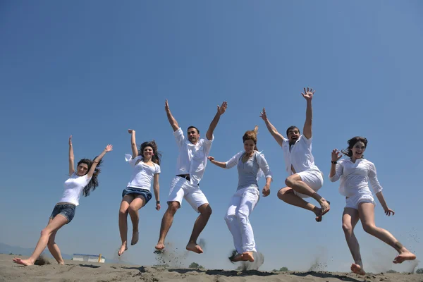 Grupa szczęśliwy mieć zabawa i działa na plaży — Zdjęcie stockowe