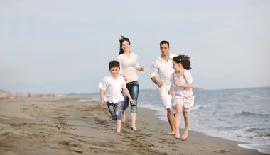 Mutlu genç aile sahilde eğleniyor.