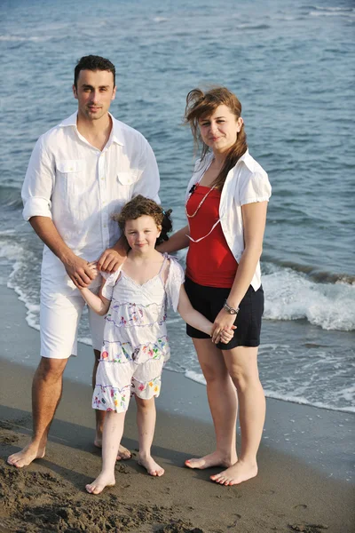 Heureux jeune famille avoir du plaisir sur la plage — Photo