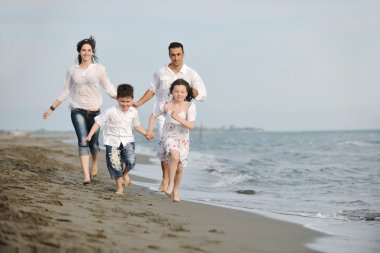 Mutlu genç aile sahilde eğleniyor.