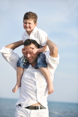 Happy father and son have fun and enjoy time on beach clipart