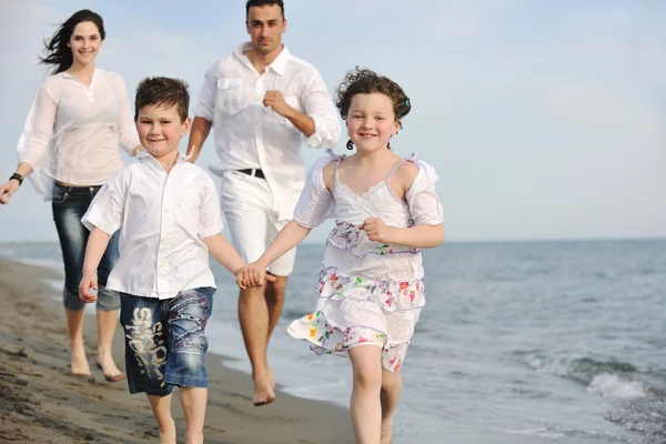 Lycklig ung familj ha kul på stranden — Stockfoto