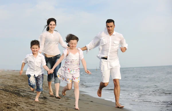 Heureux jeune famille avoir du plaisir sur la plage — Photo