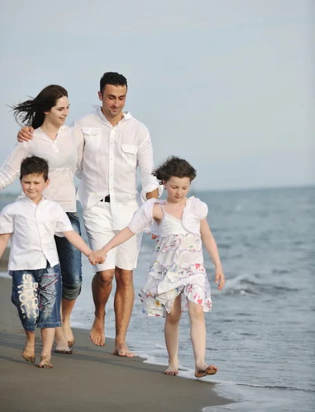 Счастливая молодая семья веселится на пляже — стоковое фото